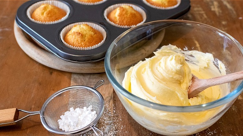 Bowl of buttercream with wooden spoon