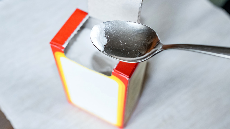 Open box of baking soda with spoon