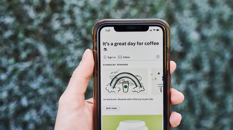 hand holding iphone with starbucks app open