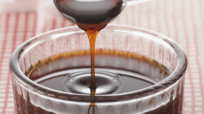 Caramel being poured into a cup via spoon