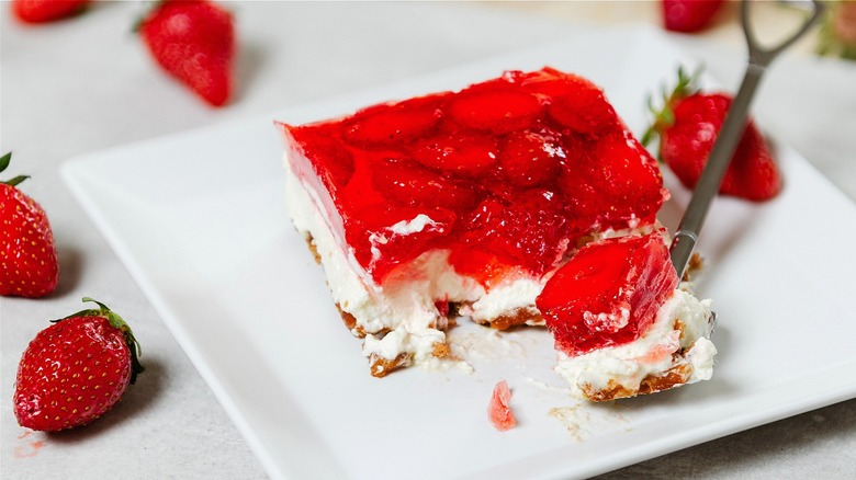 Portioned strawberry pretzel salad with fork 