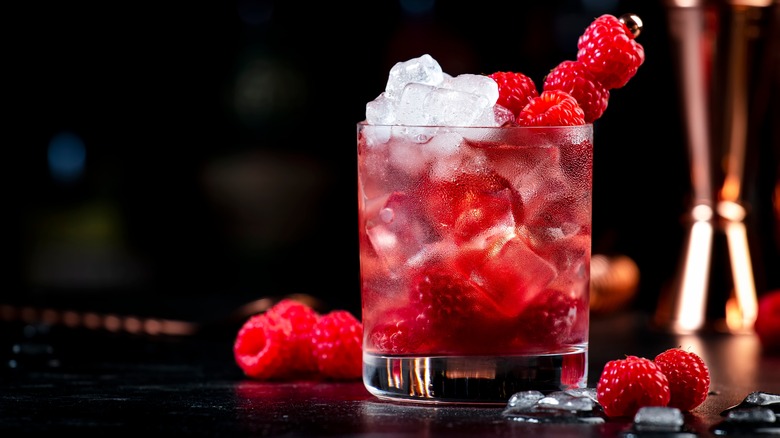 Cocktail with raspberry skewer garnish