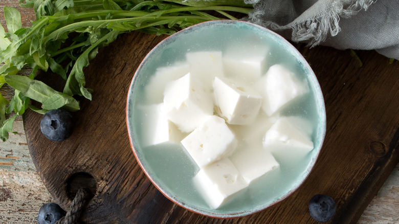 A bowl of feta cheese in brine