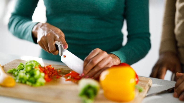 person chopping peppers in various colors