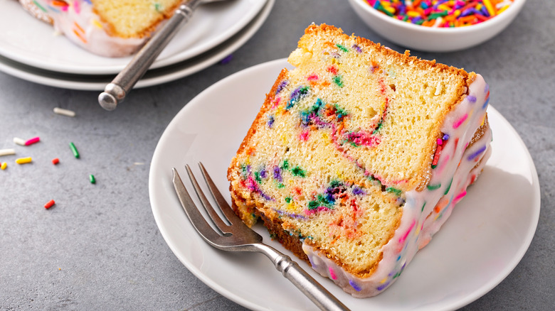 funfetti pount cake on white plate with metal fork