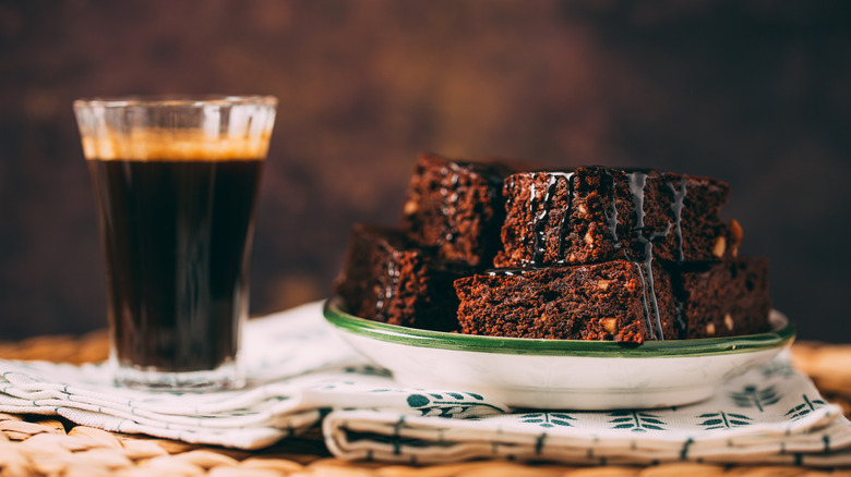 A cup of espresso beside a plate of brownies