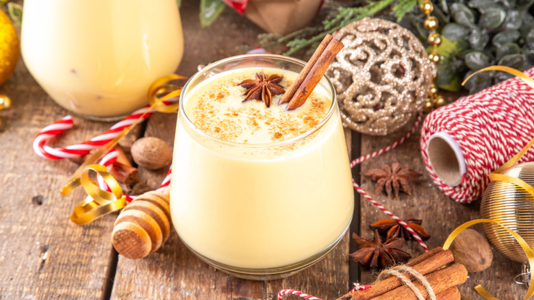 glass of eggnog surrounded by holiday decor