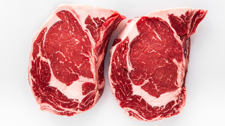 Two ribeye steaks on white background