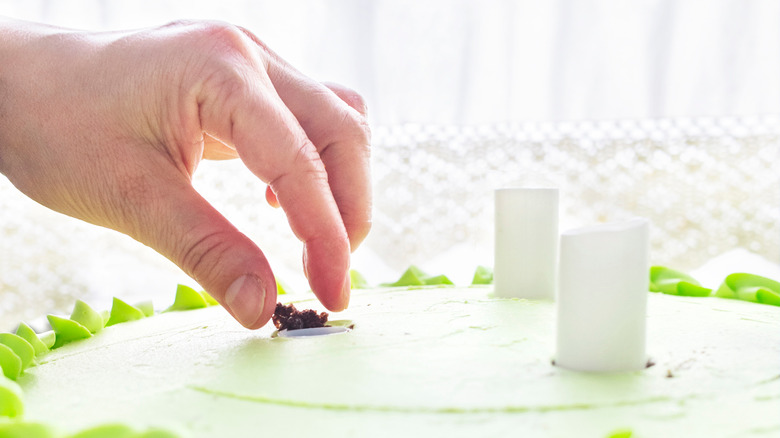 Person inserting plastic cake dowel