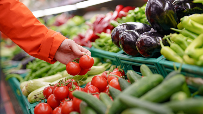 Hand reaching for tomatoes