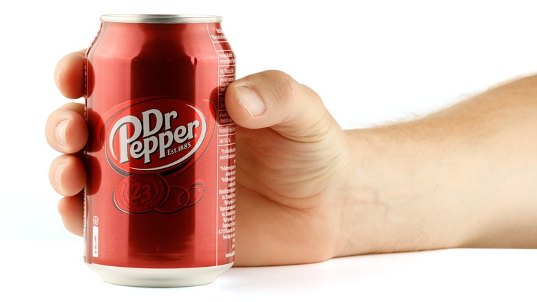 Hand grasping Dr Pepper can