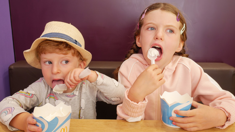 Two kids eating mini McFlurries