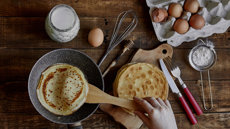 cooked crepe being taken out of pan