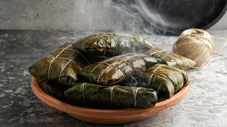 Stack of steaming tamales on a platter