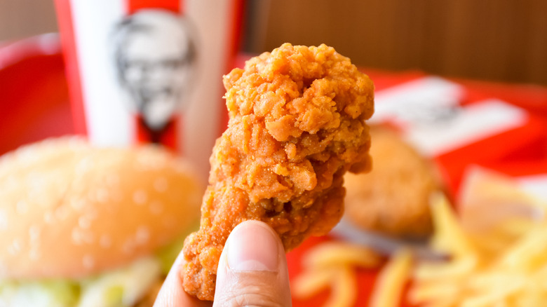 Person holding small piece of fried chicken