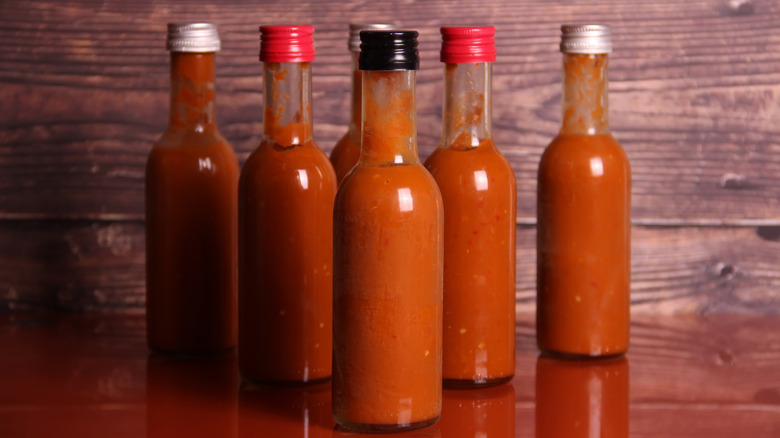 bottles of hot sauce on a wood table