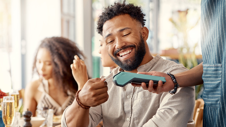 happy customer paying his tab at a restaurant