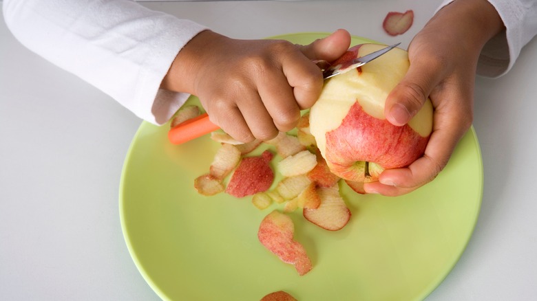 Unpeeled potatoes with a pairing knife