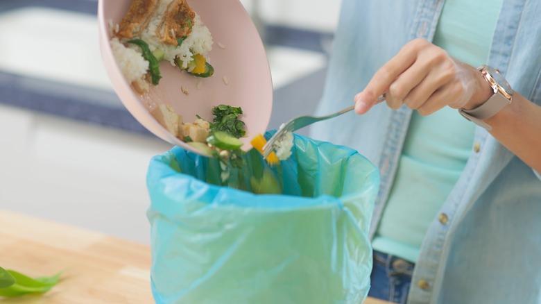 Putting food in garbage