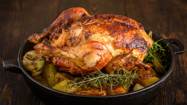 Roast chicken in a cast iron skillet with potatoes and rosemary