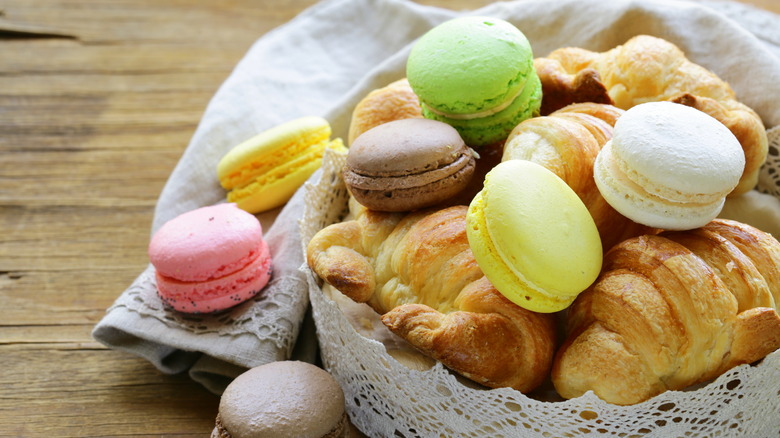 basket filled with croissants and macarons