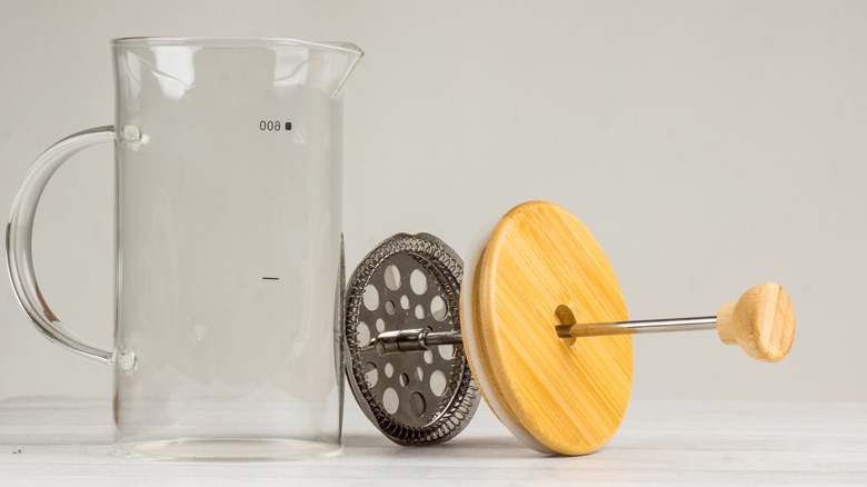 Empty French press carafe next to strainer