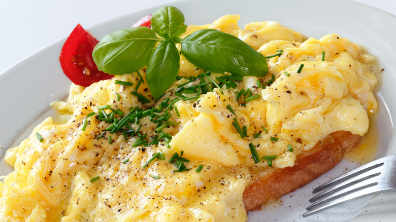 scrambled eggs on plate with basil