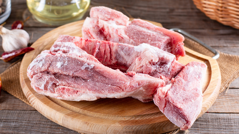 Frozen meat on a wood cutting board