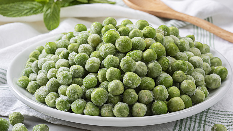 Frozen peas in a white bowl on kitchen counter