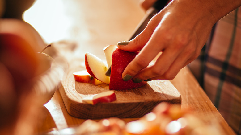 cutting red apple with knife