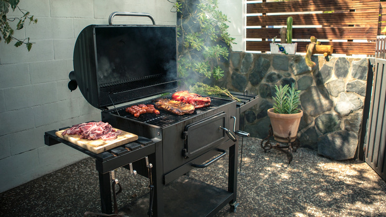 a large grill with meats on backyard patio