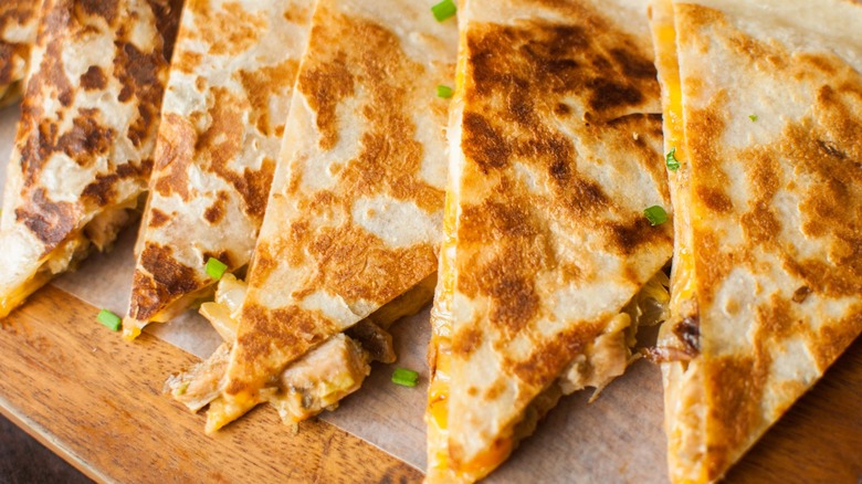 several quesadilla slices on a wooden board