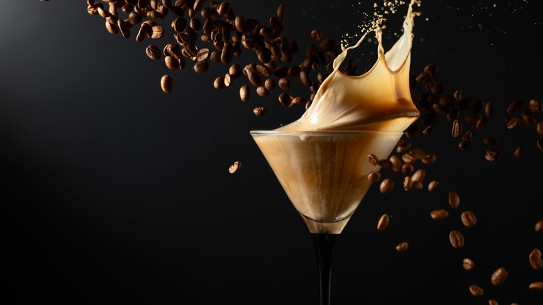 Coffee beans falling behind an espresso martini