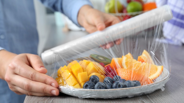 Covering fruit with plastic wrap