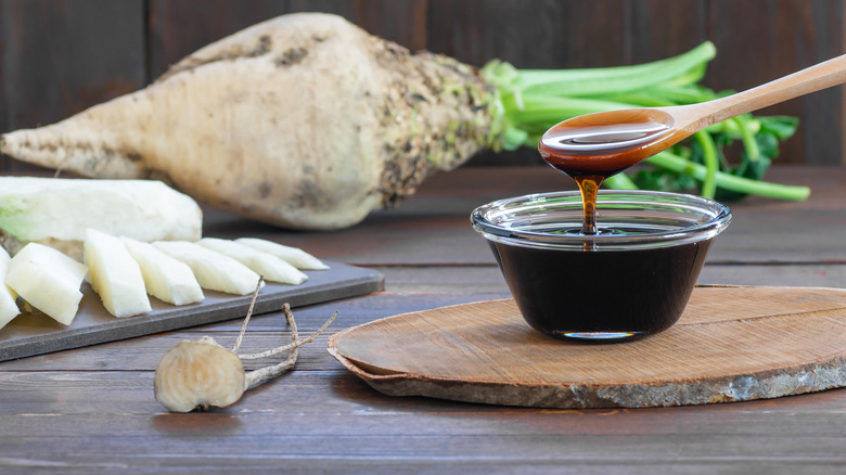 Molasses in a bowl with sugarcane 