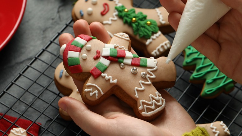 Person decorating a gingerbread man