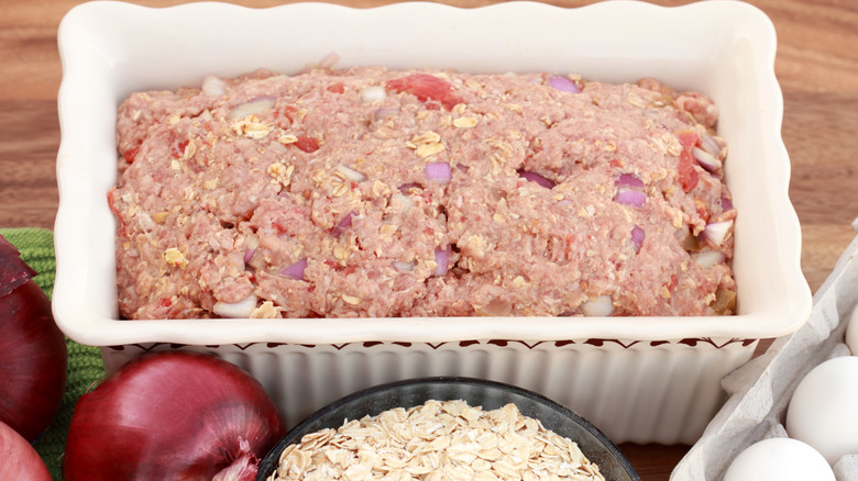 uncooked meatloaf next to bowl of oats