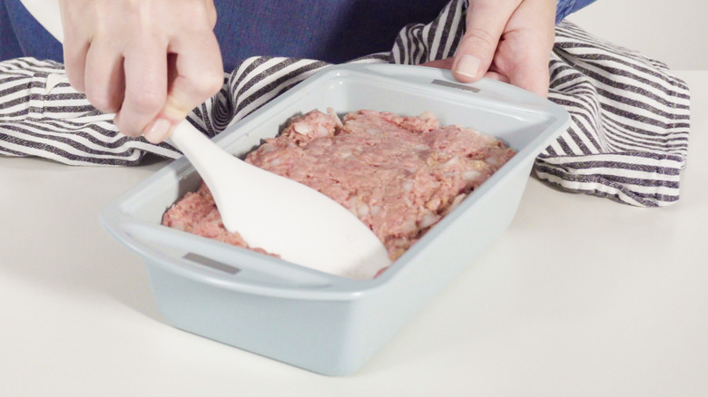 putting meatloaf mixture in a loaf pan