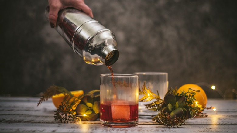 Pouring a Negroni into a glass