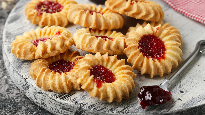 Thimble cookies with jam on wood board