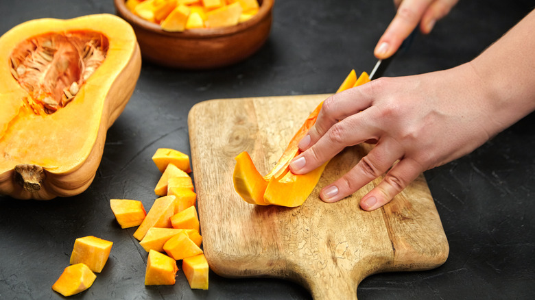 Hands cutting butternut squash