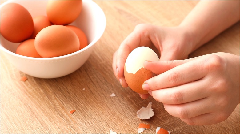 Hand peeling hard-boiled egg