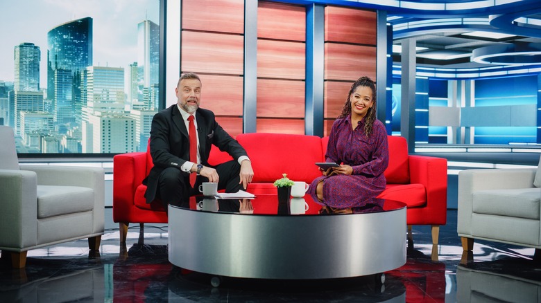 morning show hosts sitting on a couch