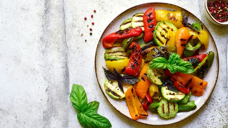 Plate of grilled vegetables with basil leaves