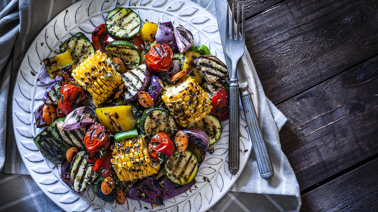 Plate of grilled vegetables on wooden background