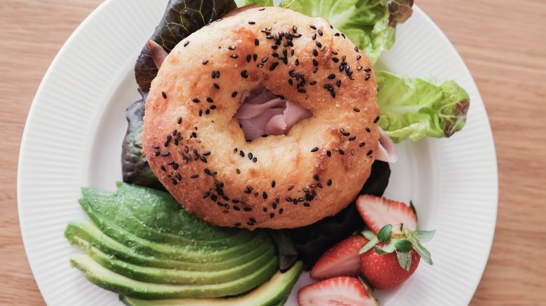 Bagel with lettuce, avocado, strawberries