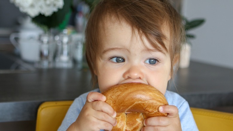 Baby eating bagel