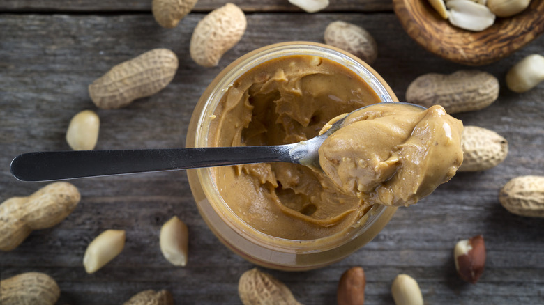 spoon full of crunchy peanut butter with jar