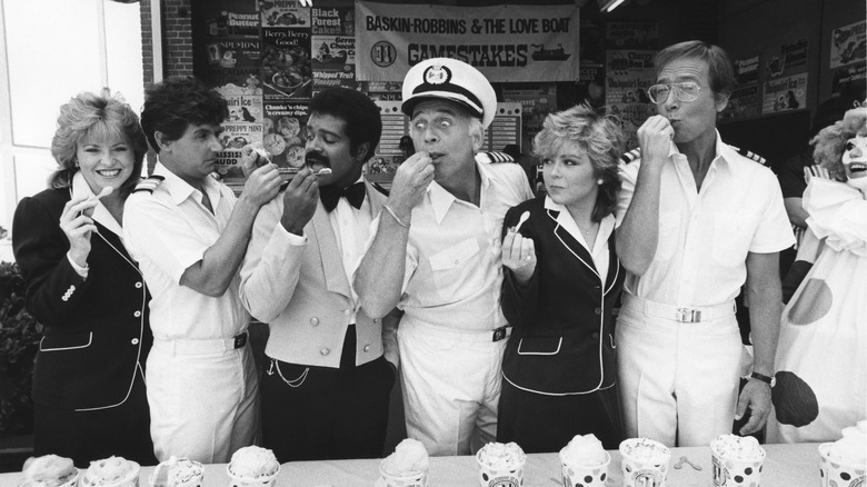 people tasting ice cream in front of baskin-robbins