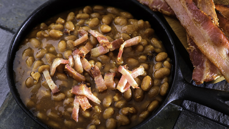 Baked beans in cast iron with strips of bacon